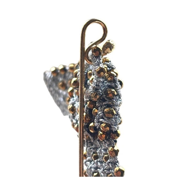 Detail of handcrafted lace gold brooch