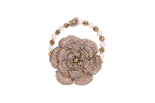 Hand~crocheted bracelet with floral design, gemstones & pearls on a white background