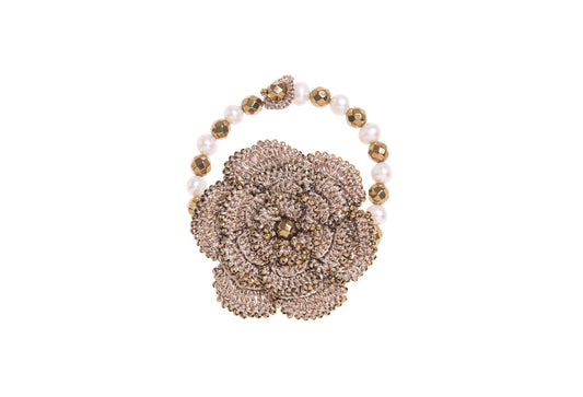 Hand~crocheted bracelet with floral design, gemstones & pearls on a white background
