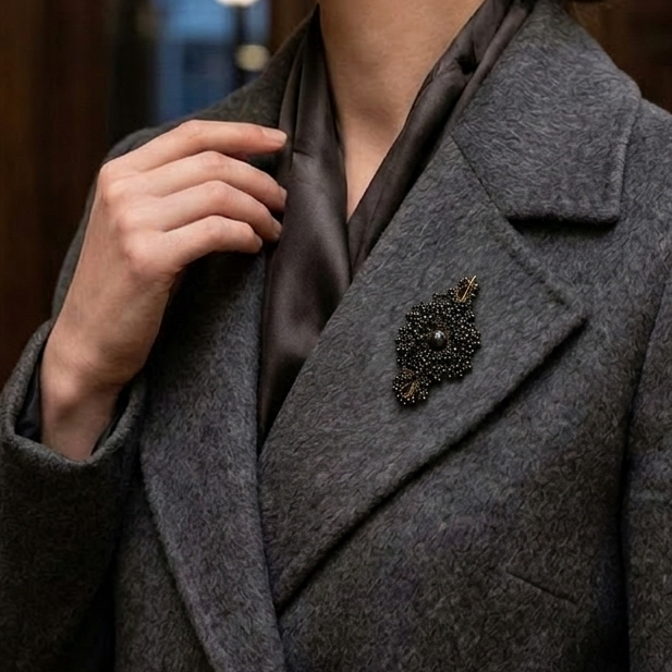 Person wearing a gray coat with a Callista handcrafted lace brooch