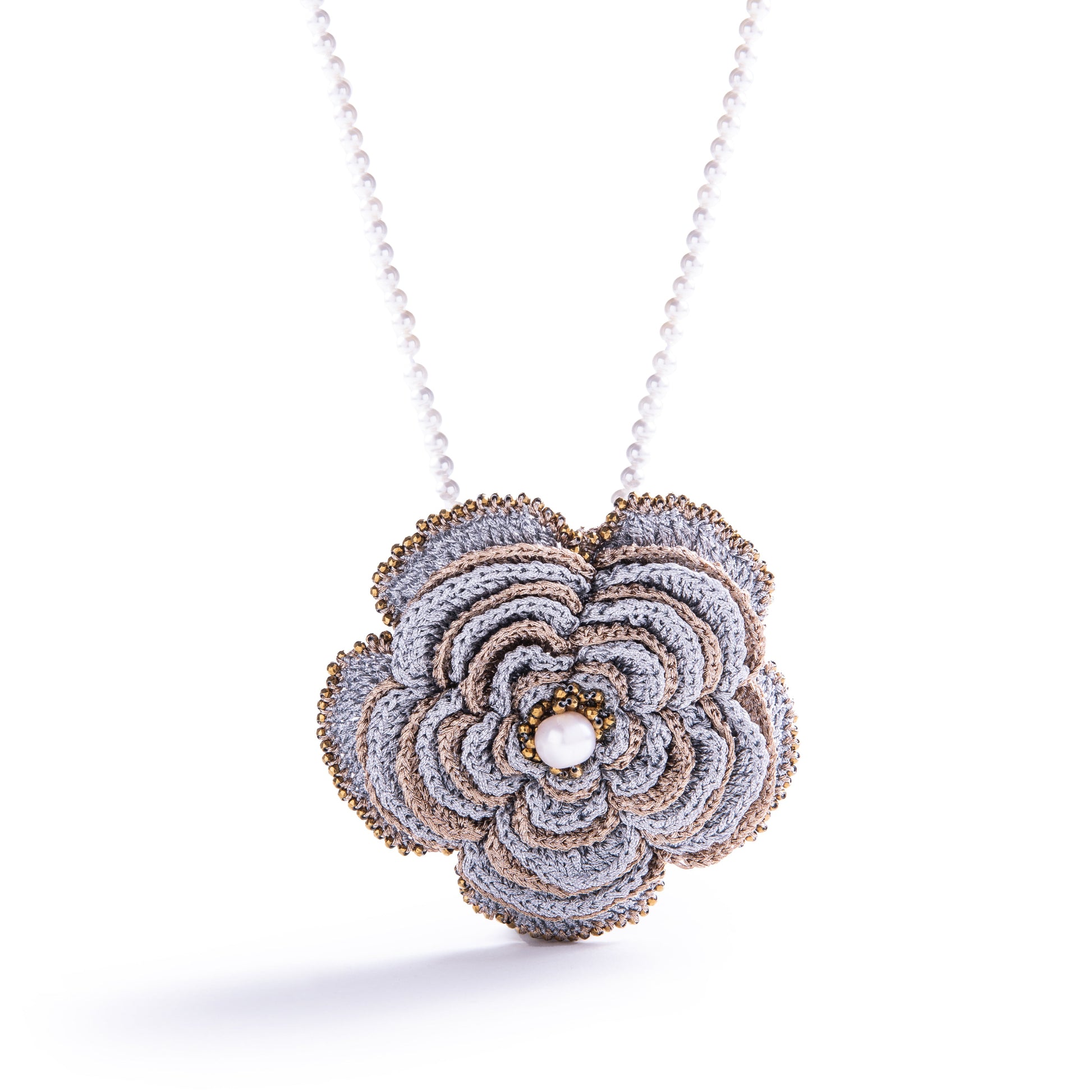 Camelia hand-crocheted brooch worn as a pendant 