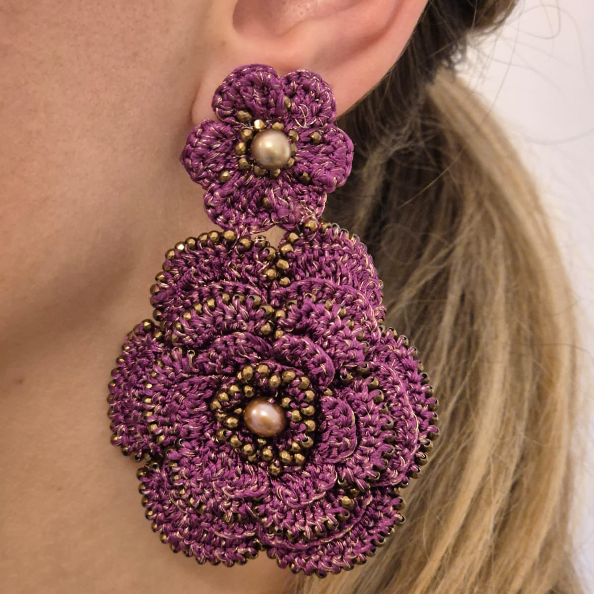 Close-up of a person wearing Camelia handmade lace earrings 