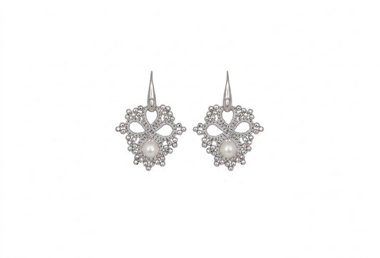 Silver handcrafted lace earrings with pearls on a white backround
