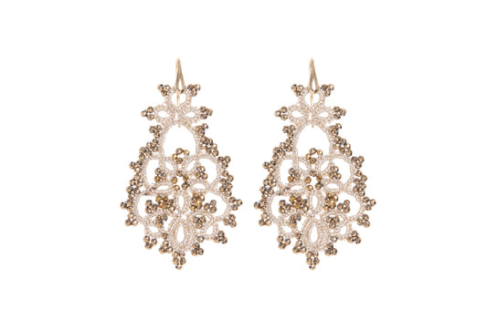 Pair of gold lace earrings on a white background