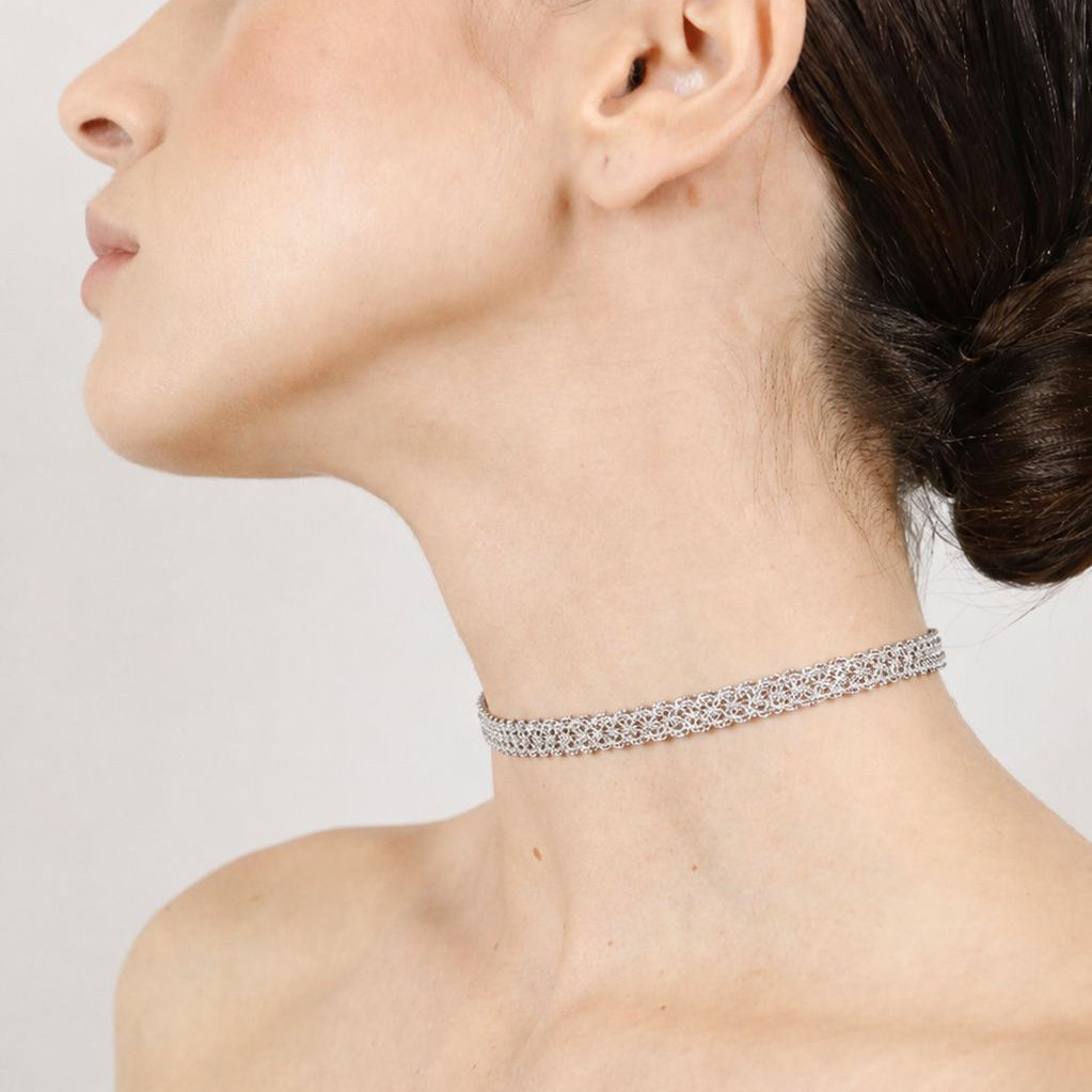 Woman wearing a handcrafted lace silver choker against a neutral background